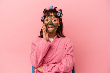 Young mixed race woman getting pretty in a house isolated on pink background shouting and holding palm near opened mouth.