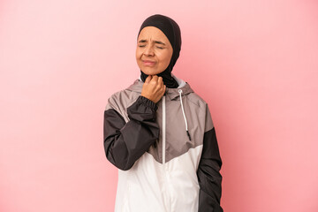 Young Arab woman with sport burqa isolated on pink background suffers pain in throat due a virus or...