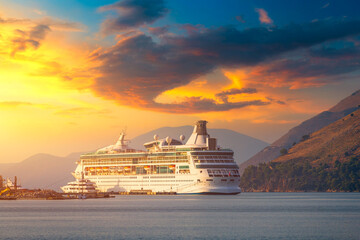 Cruise ship at harbor. Beautiful large white ship at sunset. Colorful landscape with cruiser in...