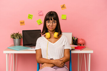 Young mixed race woman preparing a exam in the room listening to music isolated on pink background unhappy looking in camera with sarcastic expression.