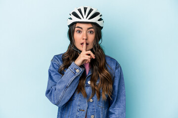 Young caucasian woman rinding a bike isolated on blue background keeping a secret or asking for silence.