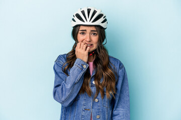 Young caucasian woman rinding a bike isolated on blue background biting fingernails, nervous and very anxious.