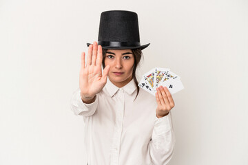 Young magician woman holding a wand isolated on white background standing with outstretched hand showing stop sign, preventing you.