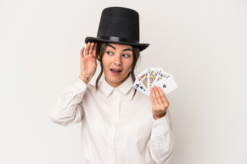 Young magician woman holding a wand isolated on white background trying to listening a gossip.