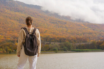 Woman hiker near lake forest in autumn on nature copy space