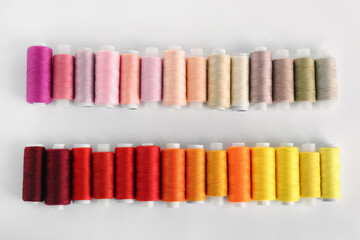 Set of colorful sewing threads on white background, top view