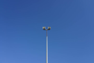 Fototapeta na wymiar Photo of a sports lantern on a sports field against a blue clear sky