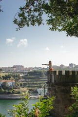 tourist in Porto, Portugal, at viewpoint crystal palace gardens pointing at city at douro river in...