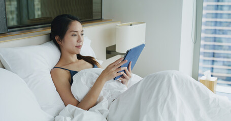 Woman look at tablet computer and lying on bed