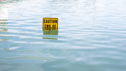 Caution sign half way under water Newport Beach California - Powered by Adobe