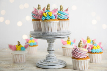 Cute sweet unicorn cupcakes on white wooden table