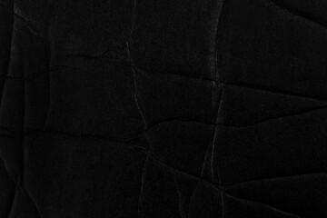 Black fractured crumpled paper surface. Broken cardboard