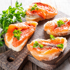 Small sandwiches with butter and salmon on table