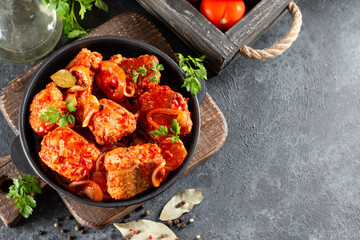 Fish in tomato sauce with lemon in a frying pan. Horizontal view from above, with copy space