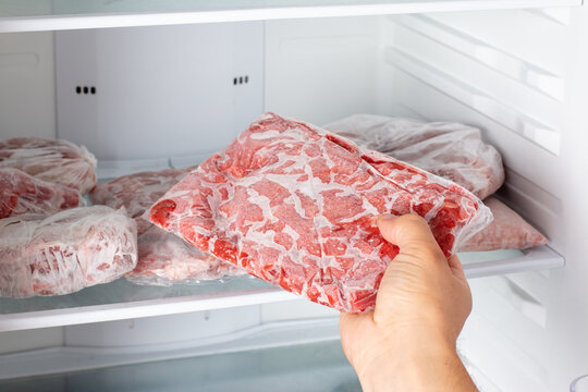 Man taking out frozen meat from freezer.