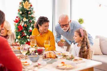 Family gathered around the table having Christmas dinner at home