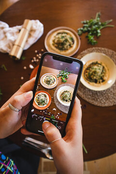 woman taking picture of food on the table hummus with quinoa coriander eggplant and chickpea vegan food healthy food plant-based diet vegetarian