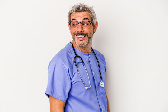 Middle age nurse caucasian man isolated on white background  looks aside smiling, cheerful and pleasant.