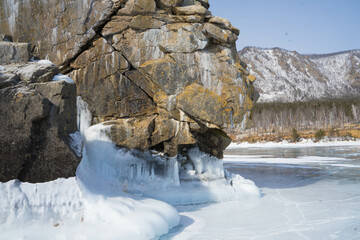 Obraz na płótnie Canvas rocks covered with snow and ice on the lake