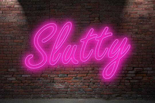 Neon Don't Sorry be Slutty lettering on Brick Wall at night