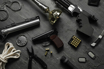 Flat lay composition with different guns on dark table