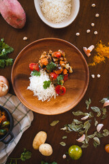 vegan food on the table rice and vegetables carrots sweet potato tomatoes coriander turmeric onions and chickpeas healthy food dish messy table plant-based diet