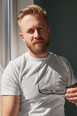 Serious man with glasses at home