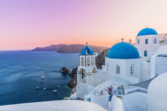 Fototapeta Greek island of Santorini. Amazing travel panorama, white houses, stairs and flowers on the streets. Idyllic summer vacation, urban landscape, tourism destination scenic. Oia, Thira panoramic views