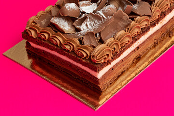 Tarta de chocolate y nata sobre fondo rosa.