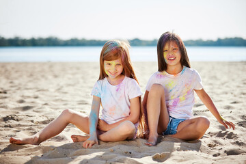 child girls smeared with colored powder having fun