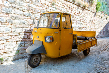 A old yellow Piaggio P 601 Ape Car is a three-wheeled light commercial vehicle produced since 1948...
