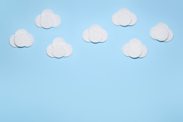 Clouds made of clean cotton pads on color background