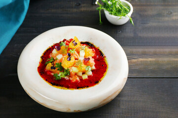 tartar salmon in white ceramic plate on wooden background