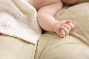 Adorable baby arm on bed, closeup