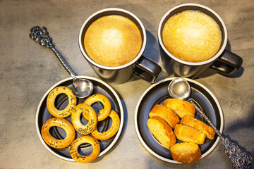 Two wooden spoons and sugar with bagels on wooden table covered with sackcloth. 
