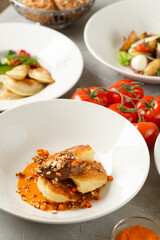 pancakes with sea buckthorn jam and lots of food in the background on concrete table closeup