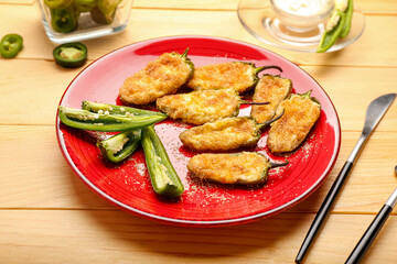 Plate with tasty jalapeno poppers on wooden background, closeup