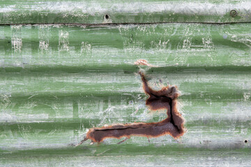 Old and aged corrugated metal painted green.