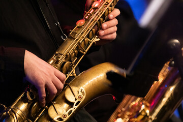 A tenor saxophone player playing a solo in front of a microphone during a live concert