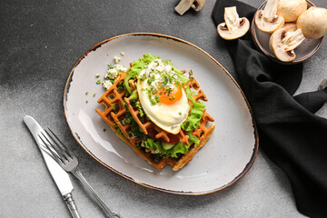Delicious Belgian waffles with egg and vegetables in plate on black and white background
