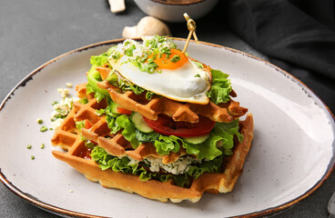 Delicious Belgian waffles with egg and vegetables on table, closeup