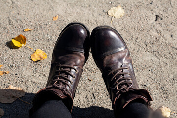 Women brown boots on the road. Autumn