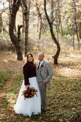 walk of the bride and groom through the autumn forest