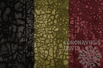 flag of belgium on a old metal rusty cracked wall with text coronavirus, covid, and virus picture.