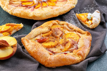 Tasty peach galette on dark background, closeup