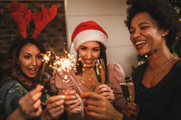 Female Friends Having Fun With Sparklers While Celebrating New Year At Home