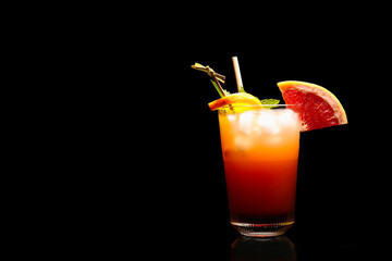 Glass of tasty Tequila Sunrise cocktail on dark background