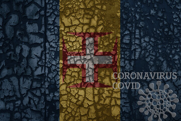 flag of madeira on a old metal rusty cracked wall with text coronavirus, covid, and virus picture.