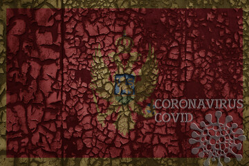 flag of montenegro on a old metal rusty cracked wall with text coronavirus, covid, and virus picture.