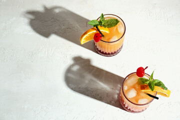 Glasses of tasty Tequila Sunrise cocktail on light background